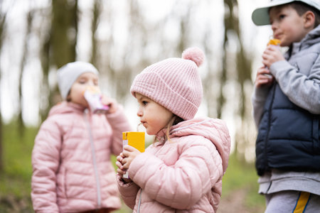 Kids drink juice using straws at forest, happy child moments.の写真素材