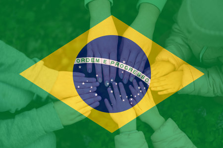 Hands of kids on background of Brazil flag. Brazilian patriotism and unity concept.の写真素材