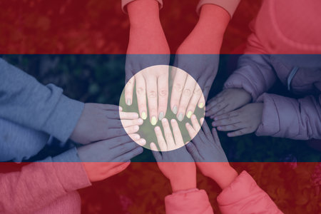 Hands of kids on background of Laos flag. Lao patriotism and unity concept.の写真素材