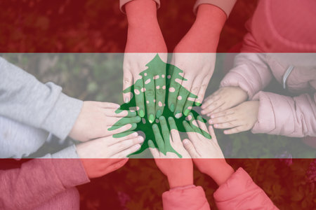 Hands of kids on background of Lebanon flag. Lebanese patriotism and unity concept.