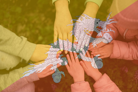 Hands of kids on background of Bhutan flag. Bhutanese patriotism and unity concept.の写真素材
