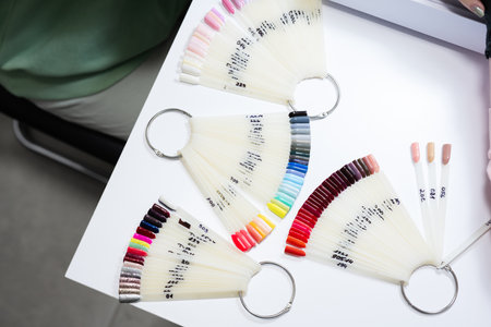 Chooses color of nail polish from palette for manicure.