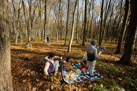Mother with kids in family picnic at autumn forest.の写真素材