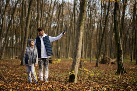 Autumn outdoor portrait of two brothers in forest.の写真素材