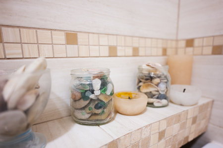 Stones in a glass jar on a shelf in the bathroomの写真素材