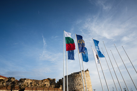 Nessebar, Bulgaria - June 2023: Flag of waving Bulgaria and UNESCO in the wind against the blue sky