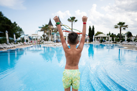 Rear view of a boy jumping into the swimming pool.の写真素材