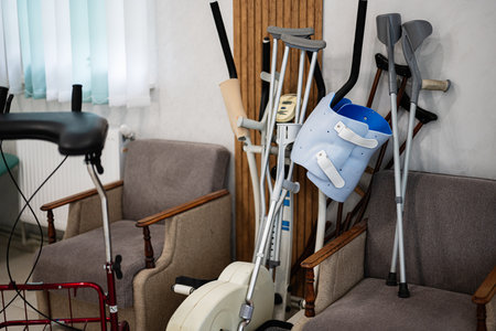 Corner of a medical room with assorted crutches, orthopedic braces, and mobility aids. The setting suggests a rehabilitation or healthcare environment, emphasizing support and recovery tools.の写真素材