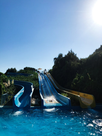 A dynamic image capturing the excitement of a water slide on a sunny day, with vibrant blue skies...