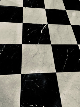 Abstract geometric pattern featuring a polished black and white marble checkerboard floor. The symmetrical design evokes elegance and timeless style, perfect for modern interior aesthetics.の写真素材