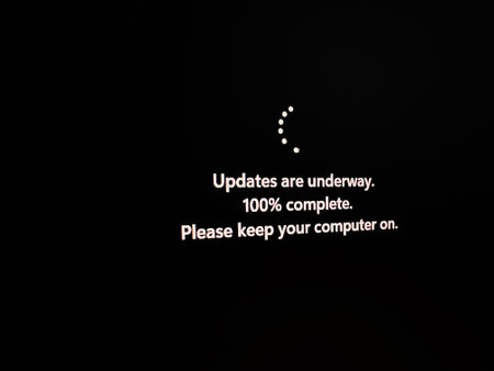 A computer screen displaying an update message indicating 100% completion. Features a rotating...
