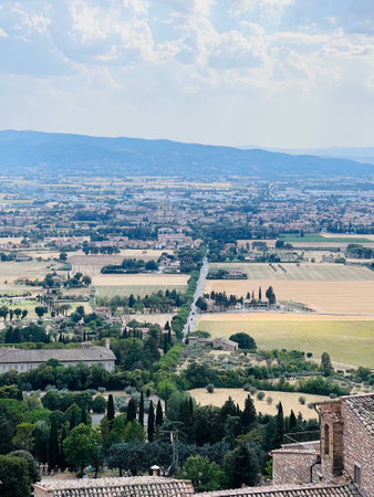 Landscape of the Tuscan countryside with lush green fields, rolling hills, and traditional architecture. This image captures the tranquil essence and natural beauty of rural Italy. Assisi, Italy.の写真素材