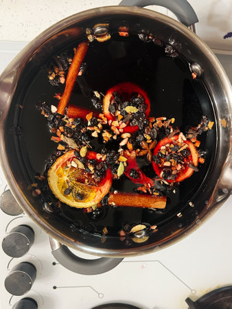 Warm and comforting beverage preparation featuring mulled wine with oranges, cinnamon, and spices, evoking festive and seasonal charm.の写真素材