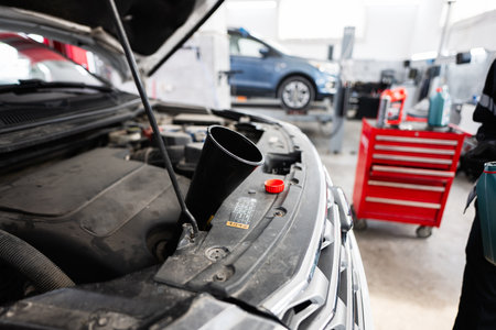 Close-up of a car's engine undergoing routine maintenance in an auto repair garage. Tools and car...