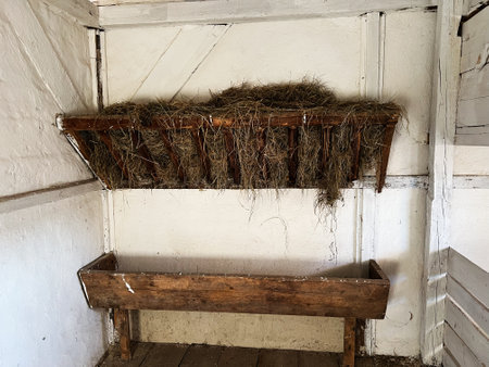 Wooden hay rack and feeding trough found inside a traditional rural farm stable.の写真素材