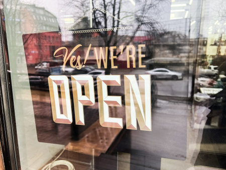 An open sign displayed on a shop window showing a vibrant and inviting atmosphere
