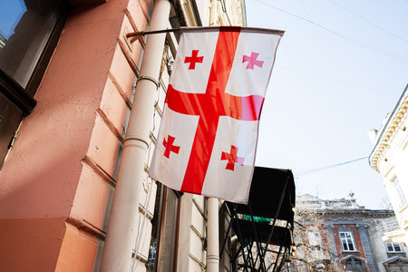 The Georgian flag is seen waving on a building on a sunny day in Ukraine.の写真素材