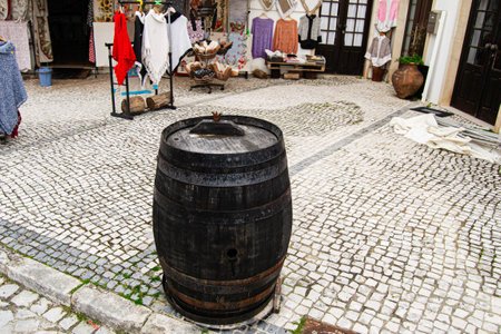 Decorative barrel on cobblestone street near textiles display in Fatima, Portugalの写真素材