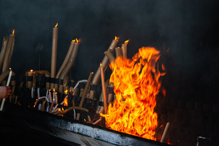 Glowing candles and vivid flames at a religious site in Fatima, Portugal