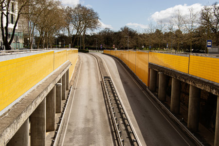 A modern roadway skirted by bright yellow walls in sunny Fatima, Portugal