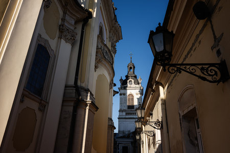 St. George's Cathedral. A beautiful church tower highlighted by sunlight amid surrounding historic buildings in Lviv, Ukraine.の写真素材