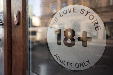 Glass door with a sign indicating 18+ entry limitの写真素材