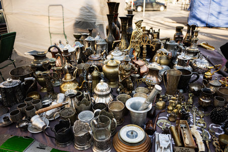 Assorted vintage utensils and antiques presented on a table at a street marketの写真素材