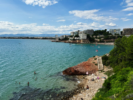 A beautiful beach coastline of La Pineda with clear waters and city views.の写真素材