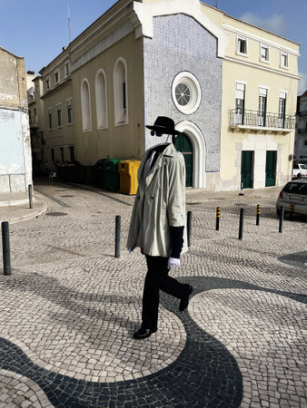 Man strolling past a historic building on a paved street in Lisbon, Portugal.の写真素材