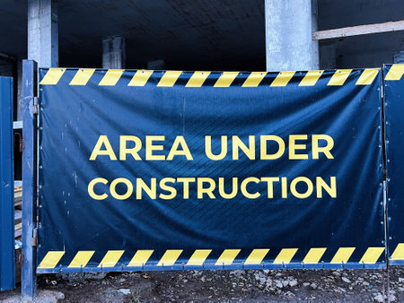 Blue banner at a construction site with safety warning and hazard design.の写真素材