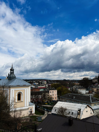 A peaceful urban landscape featuring buildings, a church, and a vivid cloudy sky. Buchach, Ukraine.の写真素材