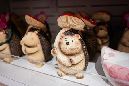 Adorable hedgehog decorations with mushrooms arranged neatly for sale on a shelf.