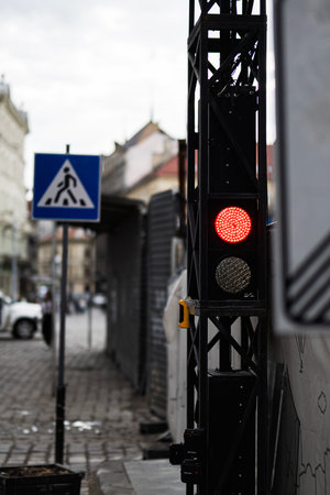 A pedestrian crossing and traffic signal in a city setting with muted lighting