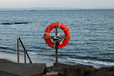 Lifesaver and helmet positioned near the ocean along the Akranes coastline.の写真素材