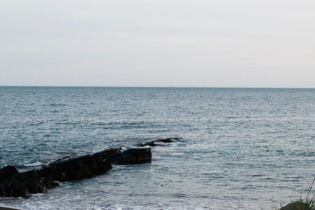 Peaceful ocean scene with rocks and waves at Akranes, Iceland during daytime.の写真素材