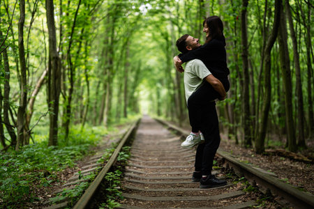 Tunnel of Love. Loving couple embracing on a railway track surrounded by lush green treesの写真素材