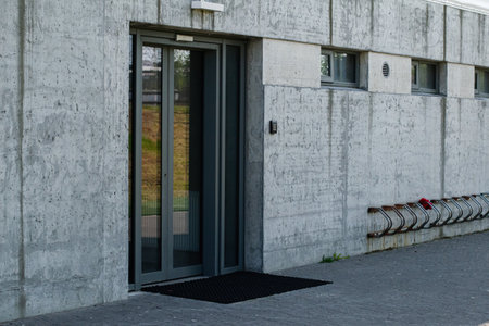 Concrete building with a glass door entry and bike rack in urban MosfellsbÃ¦r.