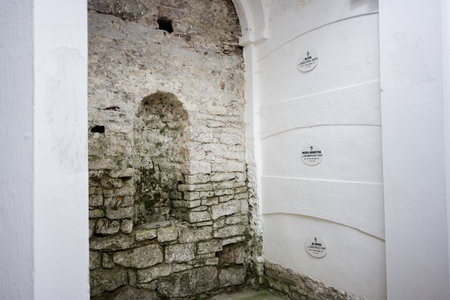 Catholic columbarium showcasing aged stone walls and plaques commemorating nuns in serene space