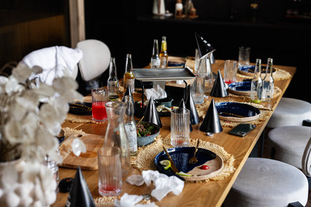 Empty table adorned with party decorations, drinks, and remnants of a fun celebration.の写真素材