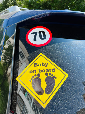 Car window with baby safety sign and a speed limit indicator in view.の写真素材