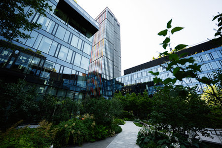 Contemporary glass buildings with landscaped greenery showcasing modern urban design