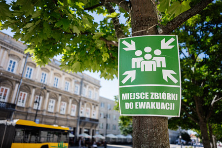 Green evacuation point sign displayed in a public area in Warsaw, Poland.の写真素材