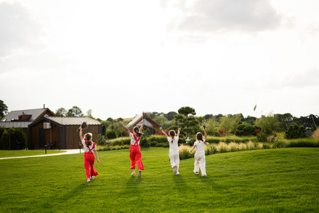 Happy kids running and playing on a grassy field in the countryside