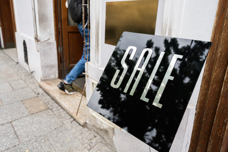 A sleek sale sign outside a boutique entrance