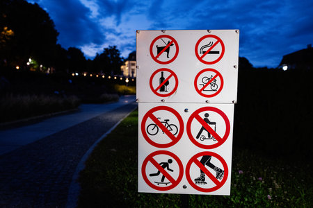 Prohibition signs at a park pathway in Rzeszow, Poland during evening hours.の写真素材