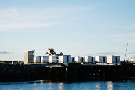 An abandoned dock with weathered boat and structures under the serene Icelandic skyの写真素材
