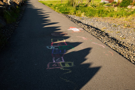 A vibrant chalk hopscotch game drawn on a sunny path in Icelandの写真素材