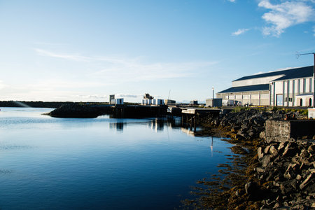 Beautiful harbor with waterfront buildings reflecting on calm waters in Iceland.