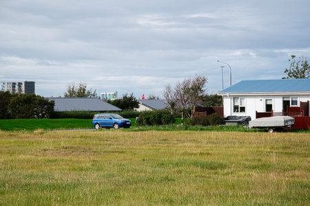 A scenic Icelandic countryside house with parked car and serene green surroundingsの写真素材