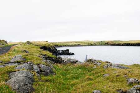 Serene view of rocky shores and tranquil waters in a coastal Icelandic landscape.